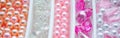 Banner with variety of pearls and beads pink, orange, white, violete colors and transparent for crafts. As a delicate background.