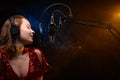 Banner. Vocalist sings in the studio. Practice and school of vocal. Music and teaching. Effective photo with blue and orange smoke Royalty Free Stock Photo