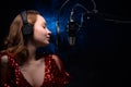 Banner. Vocalist sings in the studio. Practice and school of vocal. Music and teaching. Effective photo with blue and orange smoke Royalty Free Stock Photo