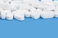 Banner of white tablets or pills on blue table. Medicine and pharmacy Royalty Free Stock Photo