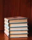 Banner with wide bookshelf and a stack of hardcovered books with bookmarks.