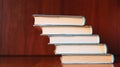 Banner with wide bookshelf and a stack of hardcovered books with bookmarks.