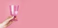 Banner with woman hand holding glass on pink background. Valentines day concept. Copy space Royalty Free Stock Photo