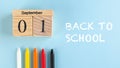Banner with a wooden September 1 calendar, colored pens and back to school text on a blue background. Copy space