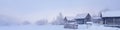 Banner 4x1 with a winter mountain landscape and a snow-covered village with sheds and logs of firewood Royalty Free Stock Photo