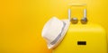 Banner yellow suitcase, with a hat for recreation, the beach and sunglasses. Travel Things Concept Festive Adventure Travel, on Royalty Free Stock Photo