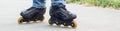 banner of Young man in blue jeans riding roller skates in the city. Close up legs