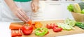 Banner. young pretty woman in green shirt cutting cooking and knife preparing fresh vegetables salad for good healthy in kitchen a Royalty Free Stock Photo