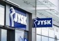 The banners of Jysk company above the entrance to the shop where houseware is sold