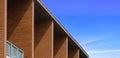 Bannister with artificial wood shading fins on upstairs of modern row houses against blue sky background in panoramic view Royalty Free Stock Photo