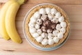 Banoffee cake with banana and caramel sauce filling sprinkled with grated dark chocolate on the wooden rustic background