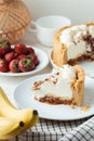 Banoffee cake slice with banana and caramel sauce filling sprinkled with grated dark chocolate on the white marble background.