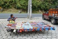 Local indigenous Ecuadorian man plays the banjo while selling local handicrafts on side of road