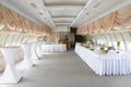 Banquet hall of restaurant remade from a passenger plane cabin, tables set with drinks and meals Royalty Free Stock Photo