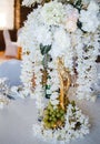 Banquet round tables, decorated with a bouquet of white flowers in the center of the tables