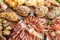 Banquet table with meat products, pistachios, olives, dried fish, chips and other snacks Royalty Free Stock Photo