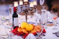 Banquet table with yellow quinces, buns or cakes and bottle of wine gathered in traditional Romanian towel.