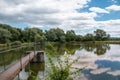 Banska Bystrica, Slovakia. Trees mirror reflection in the water. Fishing place. Shining sun over the fish pond in summer day Royalty Free Stock Photo