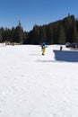 Bansko, Bulgaria, April 03, 2018: Children who learn to ski on a ski slope, skiers on ski slopes. Mountain with pine trees, people