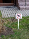 A warning sign mounted on the lawn with information on the prohibition of walking dogs Royalty Free Stock Photo