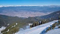 Bansko ski resort in the Pirin mountains with chairlifts moving above the snowy slopes and a panoramic view down the hills to the Royalty Free Stock Photo