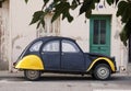 Vintage Citroen 2CV, black and yellow in colour parked on street outside house Royalty Free Stock Photo