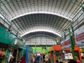 bustling atmosphere inside a traditional market with shoppers at the stalls