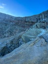 Stunning panoramic views of the Ijen Crater with large rocks and a bright blue sky in the background