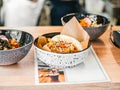 Bao with shrimp in plate. Rice buns with vegetable, seafood filling with sauce, sprinkled with sesame seeds. Poke bowl Royalty Free Stock Photo