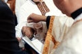 Baptism baby with holy water pouring on head at christening cer