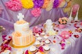 Baptism candy bar, angel statue, cupcakes, unfocused cake. Mastic cross on cake for christening child party. White candles Royalty Free Stock Photo