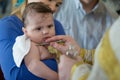 The baptism of a child.The baby is smeared with incense at the rite of baptism