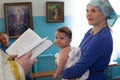 Baptism of the Child. Godmother with a child at the rite of baptism