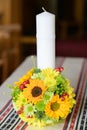 Baptismal candle with a sunflower bouquet in an Orthodox church