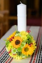 Baptismal candle with a sunflower bouquet in an Orthodox church