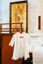 Baptismal dress on a hanger in the church. Royalty Free Stock Photo