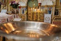 Baptismal font with blessing water and wax candles for Newborns baptism rite in Orthodox church Royalty Free Stock Photo