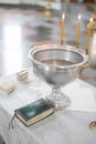 Baptismal font with wax candles is on the table near Holy Bible Royalty Free Stock Photo