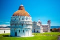 Baptistery of St. John on Square of Miracles, Leaning Tower, famous inclined tower of Pisa with green lawn in Pisa, Tuscany, Italy Royalty Free Stock Photo