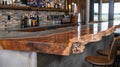 The bar area of a bat rec room features a concrete countertop with a live edge wooden bar top attached to it. This