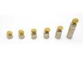Silver coin stacks of different high with top with gold coin standing on edge. Selected focus. Royalty Free Stock Photo