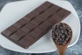 Bar of chocolate with chocolate chips on a marble background