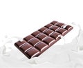 Bar of chocolate drowning in milk splashes on white background Royalty Free Stock Photo