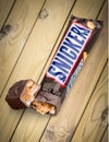 Snickers chocolate bar on wooden background Royalty Free Stock Photo