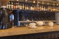 Bar counter with cup and white teapot, blurred alcohol bottles assortment Royalty Free Stock Photo