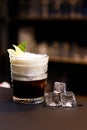 On a bar counter and a dark background. Alcoholic cocktail with ice.