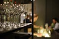 Bar counter with people drinking and bartender preparing drinks blurred in background. Selective focus on one glass Royalty Free Stock Photo