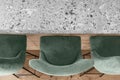 Bar counter with three bar stools and the kitchen grey stone effect countertop in minimal apartment interior.