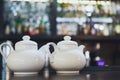 Bar counter with two white teapots