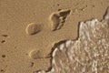 wet food step on beach with water coming close Royalty Free Stock Photo